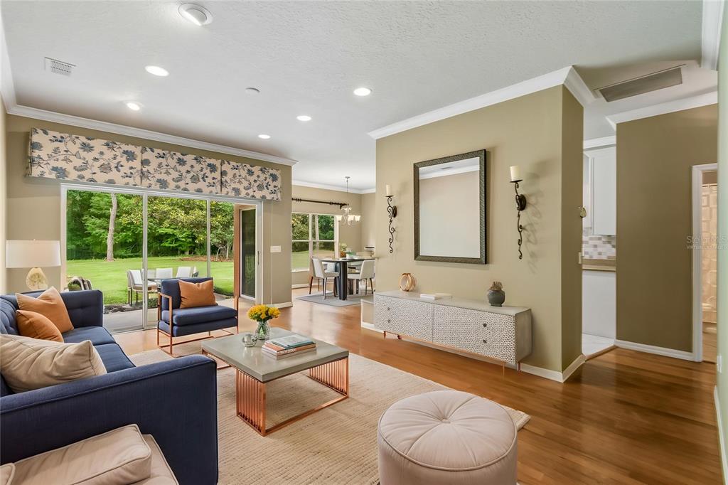 A living room with a blue sofa, a coffee table, and a view of the backyard — 136 SORRENTO RD, POINCIANA, FL