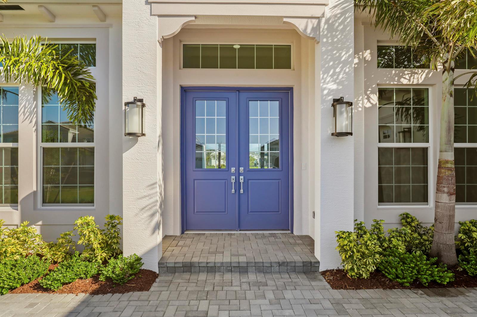 A blue double front door with glass panes is centered on a white stucco home exterior — 14823 Wildwood Circle, Westlake FL 33470, WESTLAKE, FL