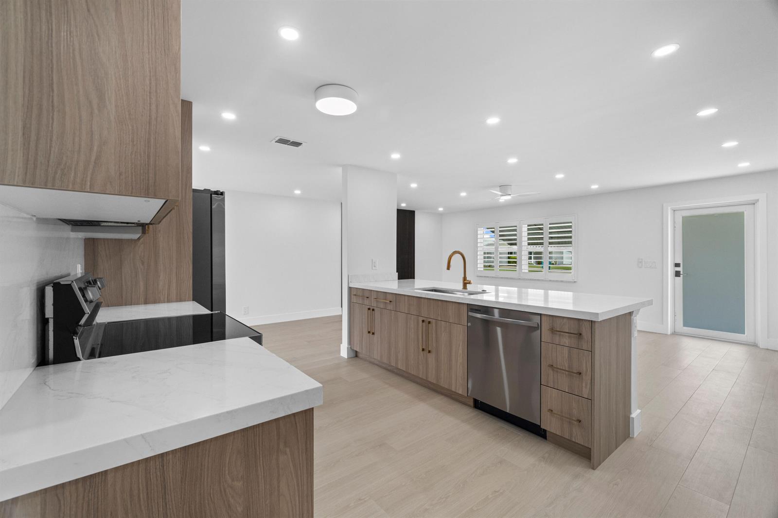 A modern kitchen features wood-grain cabinets, white countertops, stainless steel appliances, and recessed lighting — 1304 SW 23rd Street, Boynton Beach FL 33426, BOYNTON BEACH, FL