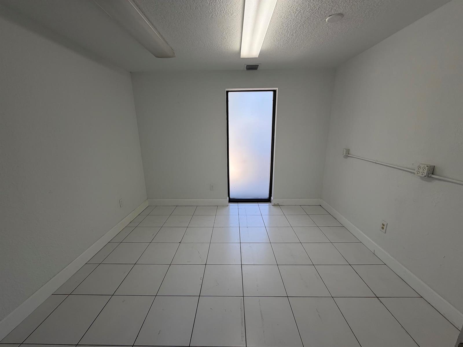 A hallway with white walls, tile flooring, a drop ceiling, and a framed boat painting — 500 Commerce Way Way W # 7, Jupiter FL 33458, JUPITER, FL