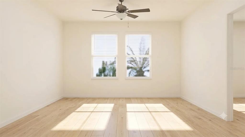 An empty room features light wood flooring, white walls, a ceiling fan, and two windows — 6011 BLUE PALOMA, PALMETTO, FL