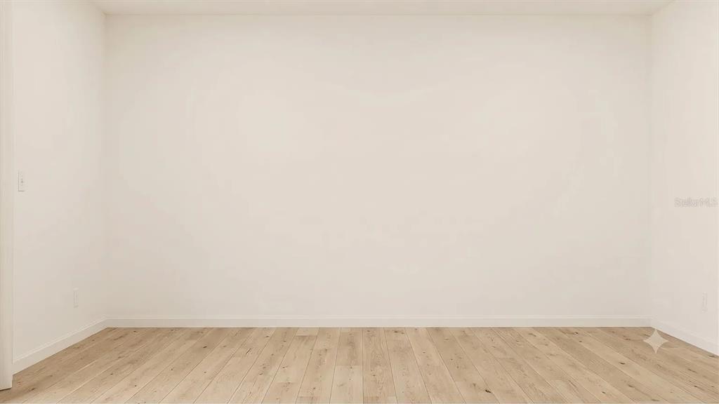 An empty room features plain white walls and light-toned wood-look flooring — 6011 BLUE PALOMA, PALMETTO, FL