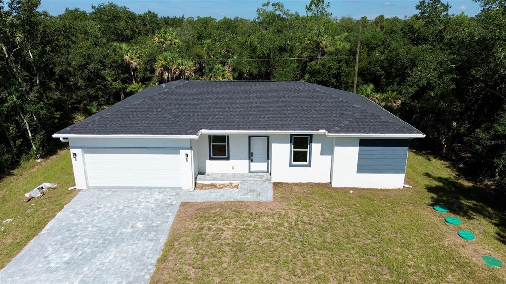An aerial view of a single-story white house with a dark roof and paved driveway — 3297 AUDETTE STREET, PORT CHARLOTTE, FL