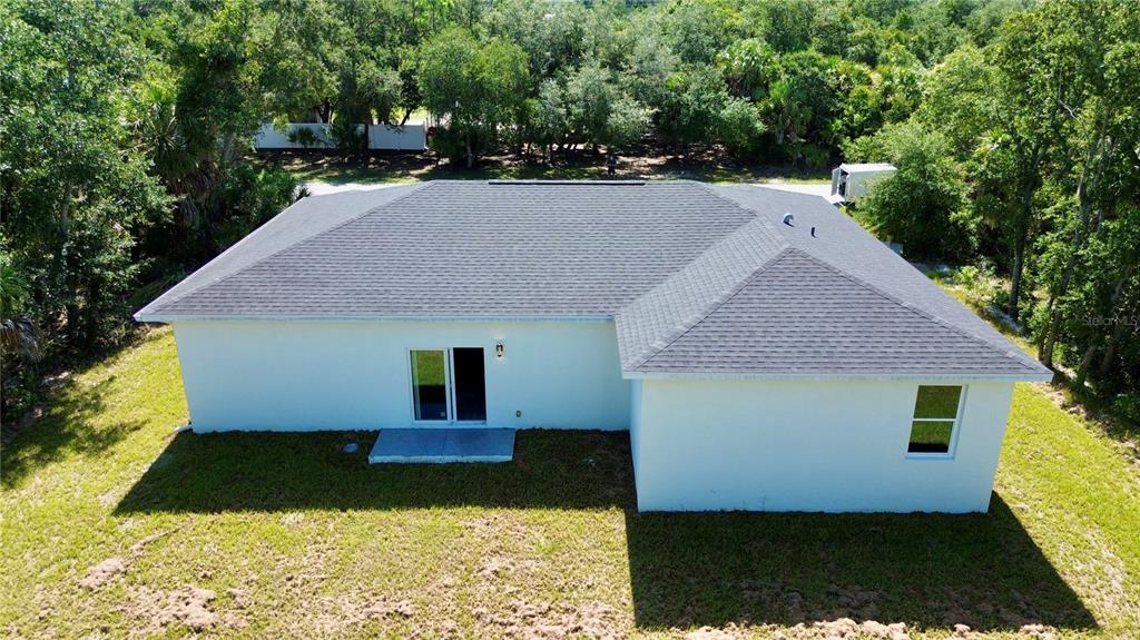 An aerial view of the back of a white house with a dark shingled roof — 3297 AUDETTE STREET, PORT CHARLOTTE, FL