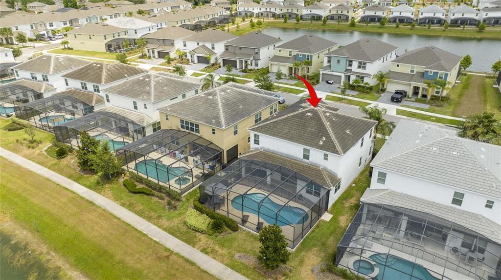 An aerial view shows a two-story house with a screened-in pool and tile roof — 280 BALLO DRIVE, KISSIMMEE, FL