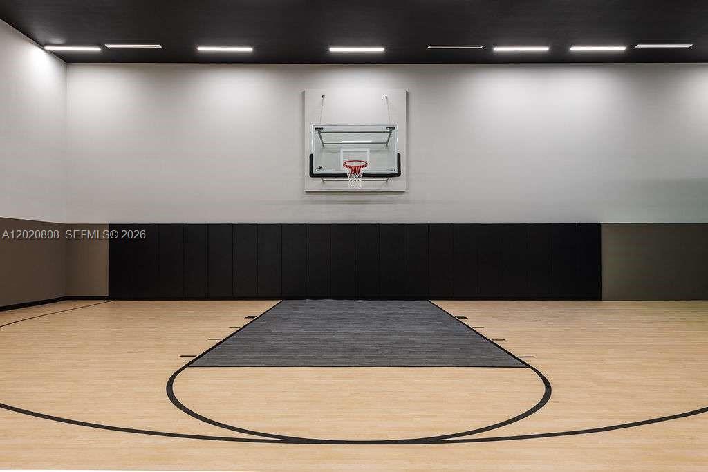 This indoor basketball court features light wood flooring, black wall padding, and recessed ceiling lighting — 225 N Miami Ave # 2810, Miami FL 33128, MIAMI, FL