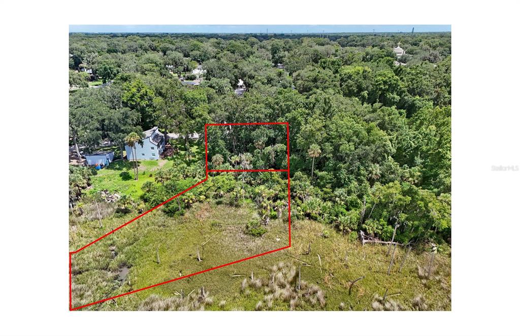 An aerial view shows a wooded lot outlined in red next to a residential house — OAK LANDINGS DRIVE, JACKSONVILLE, FL