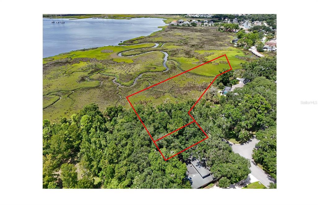 An aerial view shows a wooded lot outlined in red bordering a coastal marshland — OAK LANDINGS DRIVE, JACKSONVILLE, FL