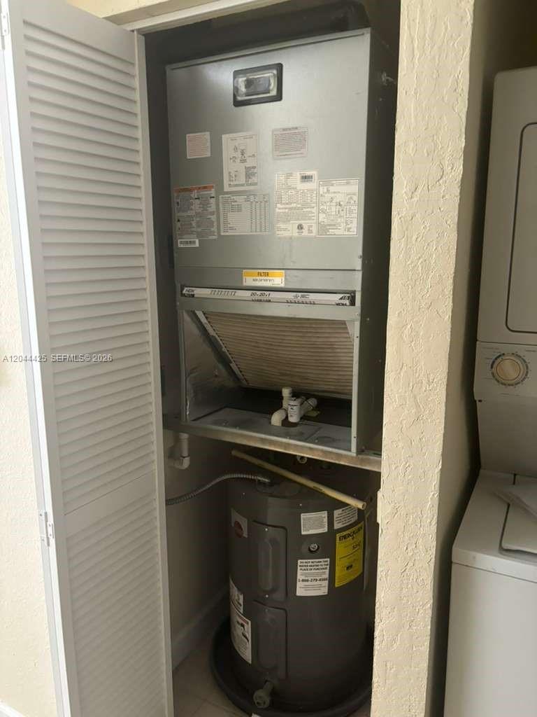 A utility closet contains an HVAC air handler unit positioned above a water heater — 1663 SE 27th Dr # 207, Homestead FL 33035, HOMESTEAD, FL