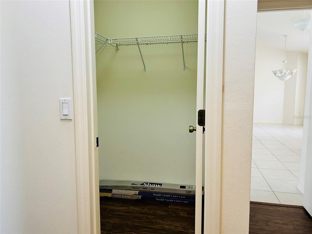 A small closet with wire shelving and boxes of vinyl plank flooring on the floor — 304 PINE GLEN COURT, ENGLEWOOD, FL