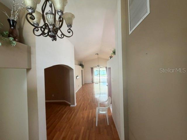 A view through a doorway shows a living area with wood floors and a chandelier — 4049 SAVAGE STATION CIRCLE, NEW PORT RICHEY, FL