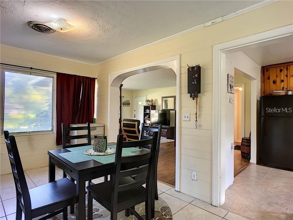 A dining area with a black table and chairs leads into a living room — 503 KILSHORE LANE, WINTER PARK, FL