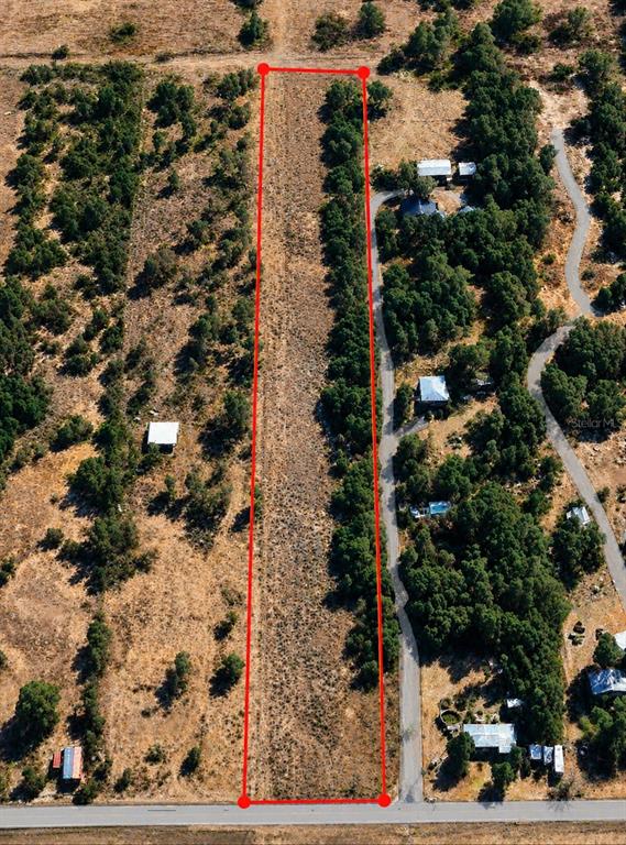 An aerial view shows a long, rectangular vacant lot outlined in red along a road — 1716 TINDEL CAMP ROAD, LAKE WALES, FL