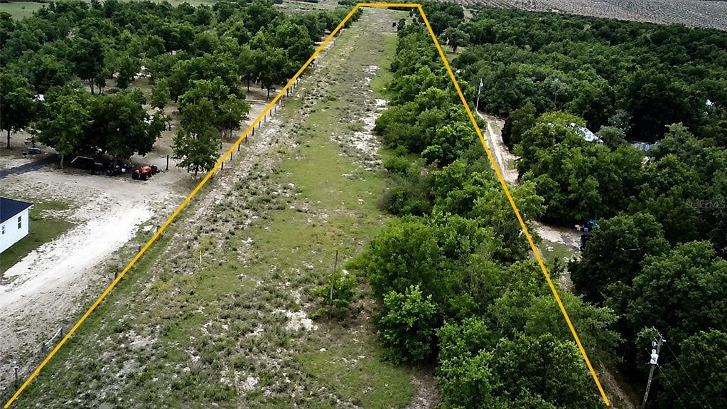 An aerial view shows a long, narrow, grassy lot bordered by trees and fences — 1716 TINDEL CAMP ROAD, LAKE WALES, FL