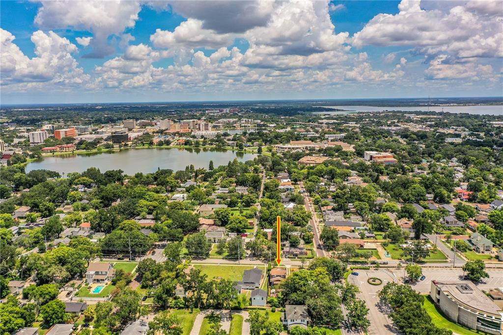 An aerial view shows a residential neighborhood with a lake and a marked house — 721 FRANK LLOYD WRIGHT WAY, LAKELAND, FL