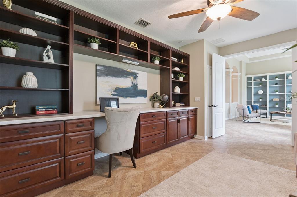 A home office features dark wood built-in cabinetry, a desk, shelving, and tile flooring — 2226 PARKSIDE MEADOW DRIVE, APOPKA, FL