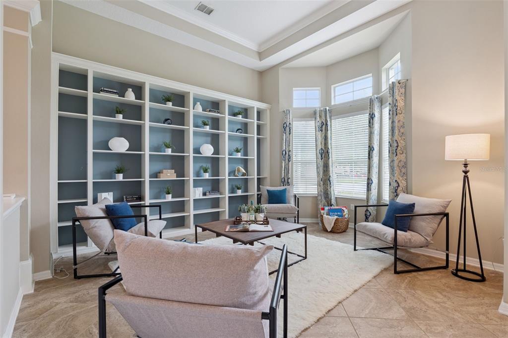 A living room features a large built-in bookshelf, four armchairs, a coffee table, and windows — 2226 PARKSIDE MEADOW DRIVE, APOPKA, FL