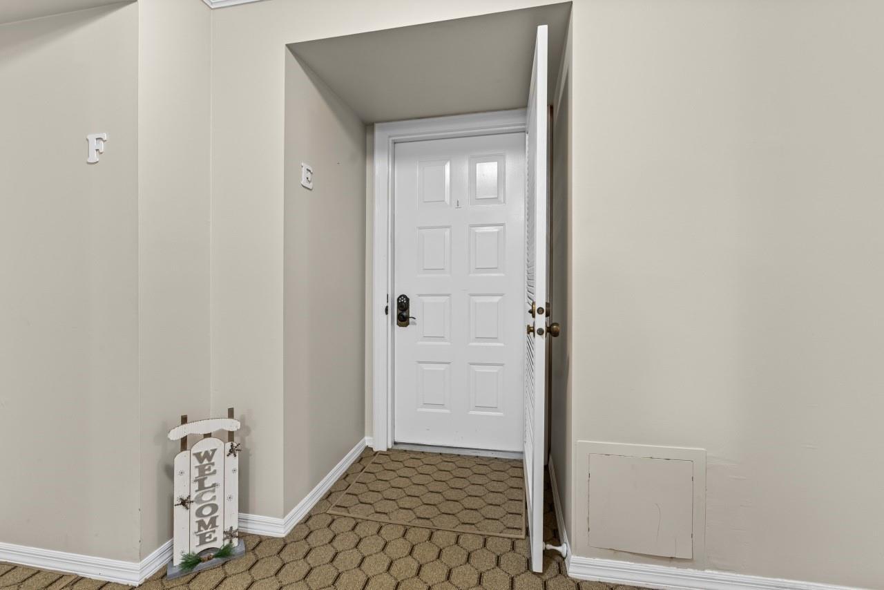 A white door with a welcome sign sits in a carpeted hallway — 1815 Mooringline Drive # 2e, Vero Beach FL 32963, VERO BEACH, FL