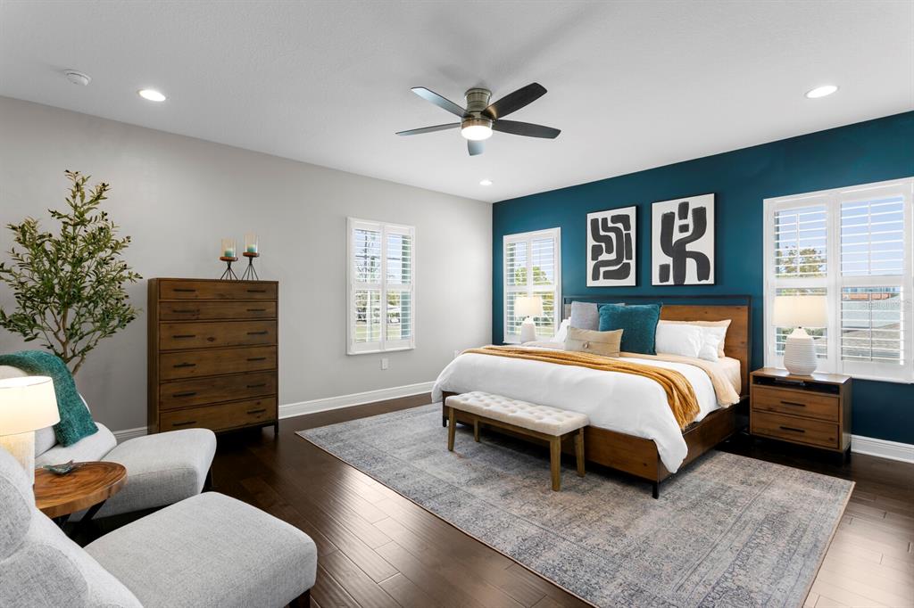 A bedroom features a dark blue accent wall, wooden furniture, and a large area rug — 2702 W CASS STREET, TAMPA, FL