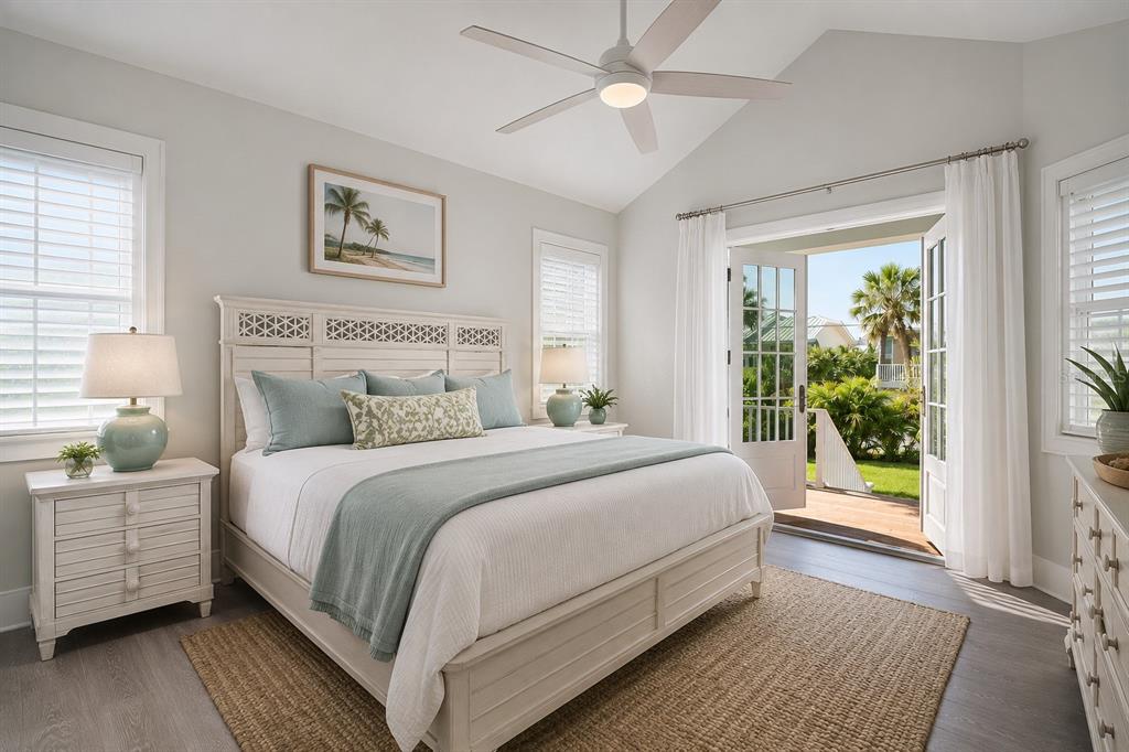 A bedroom features a white bed, a ceiling fan, and French doors opening to a deck — 16526 CUP COURT, PORT CHARLOTTE, FL