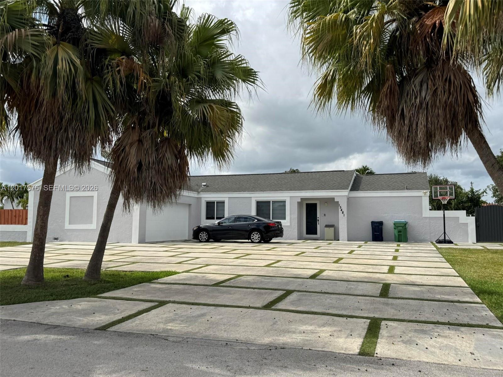 A single-story house with a gray exterior, a garage, and a concrete paver driveway — 15481 SW 155th Ter, Miami FL 33187, MIAMI, FL