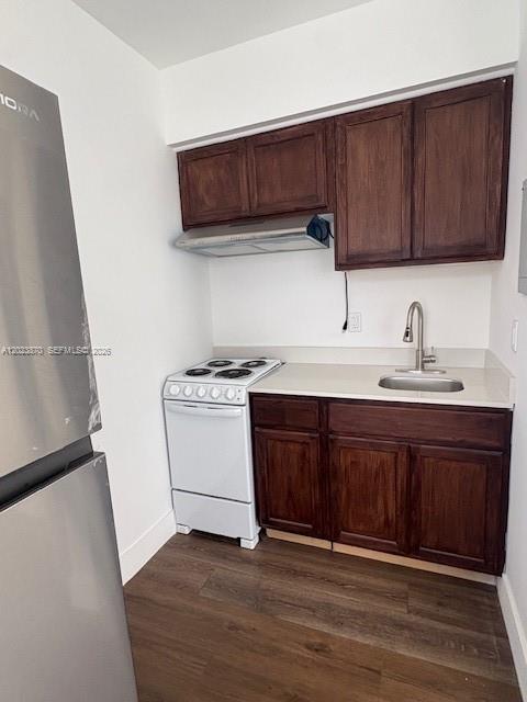 A small kitchen features dark wood cabinets, a white electric stove, and a stainless sink — 2052 SW 7th St # 4, Miami FL 33135, MIAMI, FL