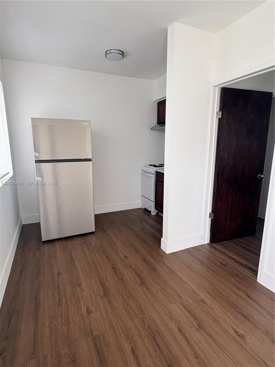 A small kitchen features stainless steel appliances, dark wood-look flooring, and white walls — 2052 SW 7th St # 4, Miami FL 33135, MIAMI, FL