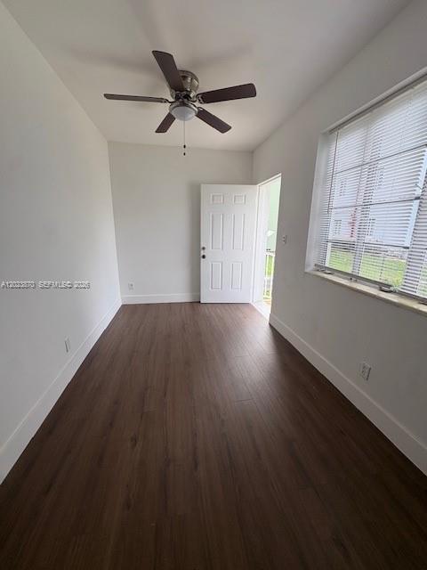 An empty room features dark wood-look flooring, a ceiling fan, and a white door — 2052 SW 7th St # 4, Miami FL 33135, MIAMI, FL