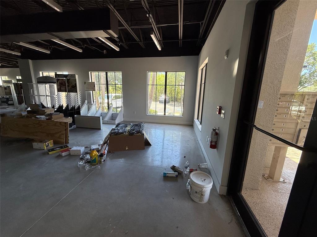 An unfinished commercial space features concrete floors, exposed black ceilings, and large windows — 5920 PAN AMERICAN BOULEVARD UNIT 104, NORTH PORT, FL