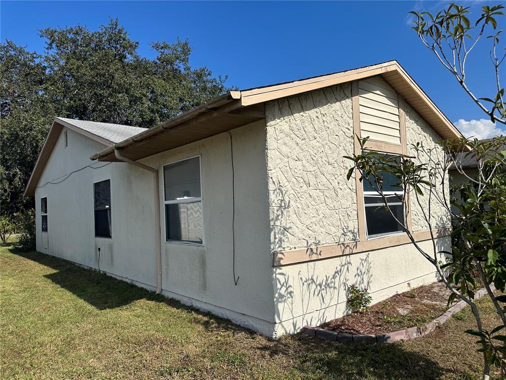 The exterior of a single-story house features stucco walls, a textured facade, and a gabled roof — 746 MADERIA COURT, KISSIMMEE, FL