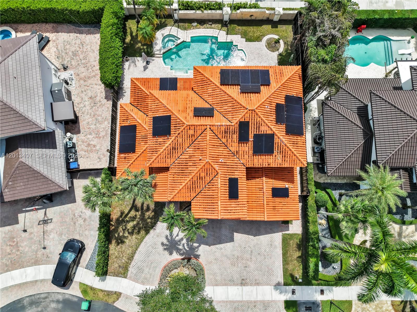 An aerial view shows a house with a terracotta tile roof and solar panels — 16101 NW 79th Ct, Miami Lakes FL 33016, MIAMI LAKES, FL