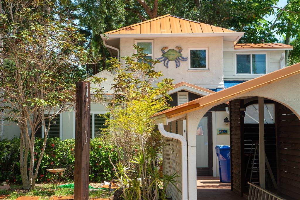 A two-story house with a metal roof, a crab wall decoration, and a wooden entryway — 219 24 STREET W, BRADENTON, FL