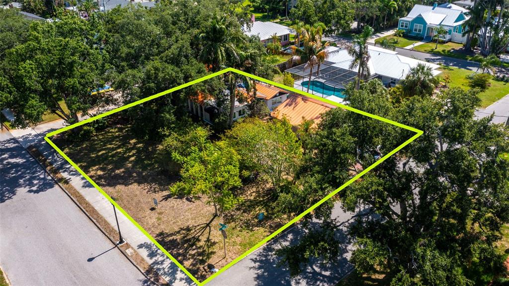 An aerial view shows a residential lot with a house, mature trees, and street access — 219 24 STREET W, BRADENTON, FL