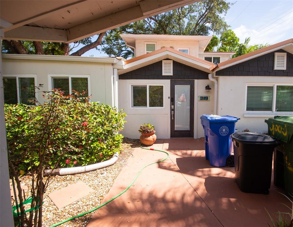 The exterior view shows a house entrance with a patio, two trash bins, and landscaping — 219 24 STREET W, BRADENTON, FL