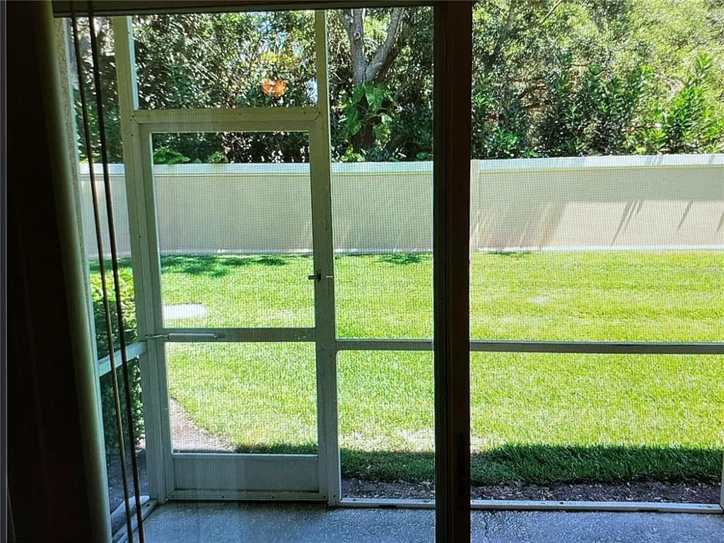 A two-story tan stucco townhouse building features four garage doors and a palm tree — 3635 PARKRIDGE CIRCLE UNIT 10-101, SARASOTA, FL