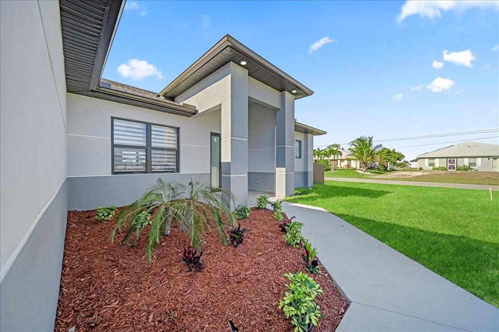 A single-story house with a brown garage door, gray exterior walls, and a green lawn — 1226 NE 5TH PLACE, CAPE CORAL, FL