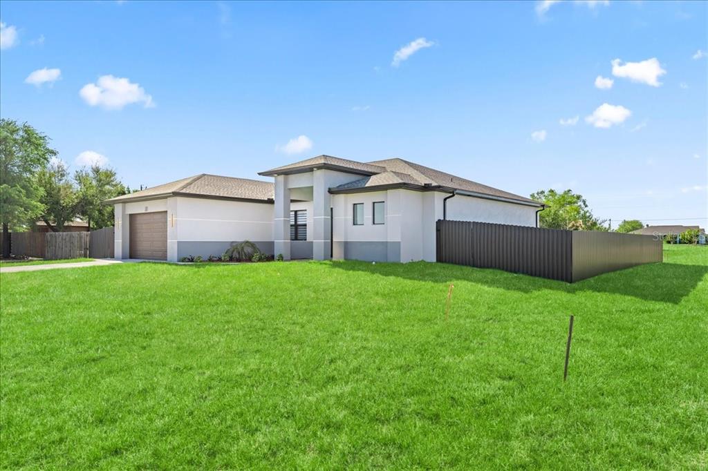A rear view of a house with a covered patio, swimming pool, and paver deck — 1226 NE 5TH PLACE, CAPE CORAL, FL