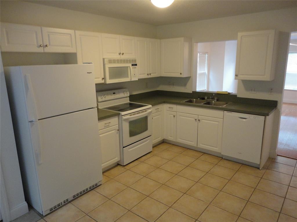 A kitchen features white cabinets, a white refrigerator, a white stove, and tile flooring — 2636 SW 35TH PLACE UNIT 8, GAINESVILLE, FL