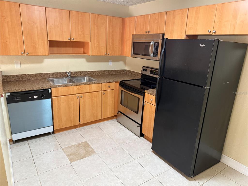 A dining area with a table and chairs next to an open kitchen — 21026 VOYAGER BOULEVARD UNIT 6, LAND O LAKES, FL