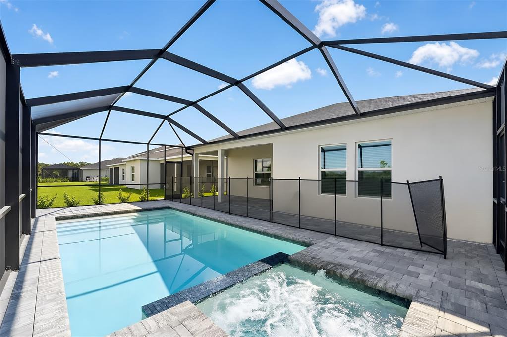 A screened-in patio features a swimming pool, a hot tub, and a paved deck area — 13302 GRASSMERE COURT, PUNTA GORDA, FL