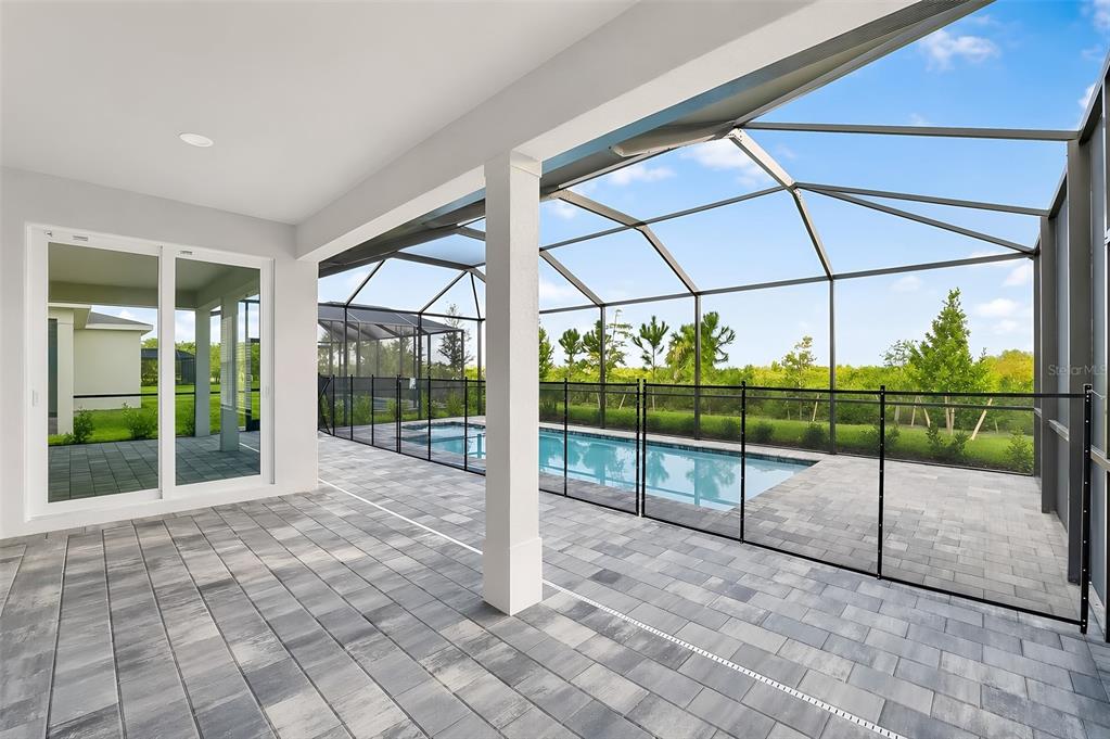 A covered patio overlooks a screened-in swimming pool and a grassy backyard — 13302 GRASSMERE COURT, PUNTA GORDA, FL