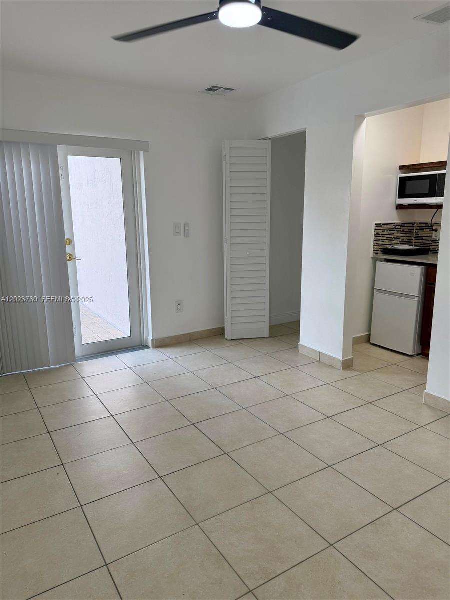 A room with tiled floors, a ceiling fan, a glass door, and a small kitchenette — 19763 SW 124th Ave # 1, Miami FL 33177, MIAMI, FL