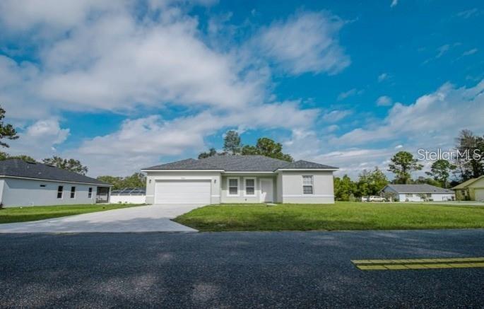 A single-story house with a white exterior, a two-car garage, and a concrete driveway — 6346 N DARLINGTON DRIVE, DUNNELLON, FL