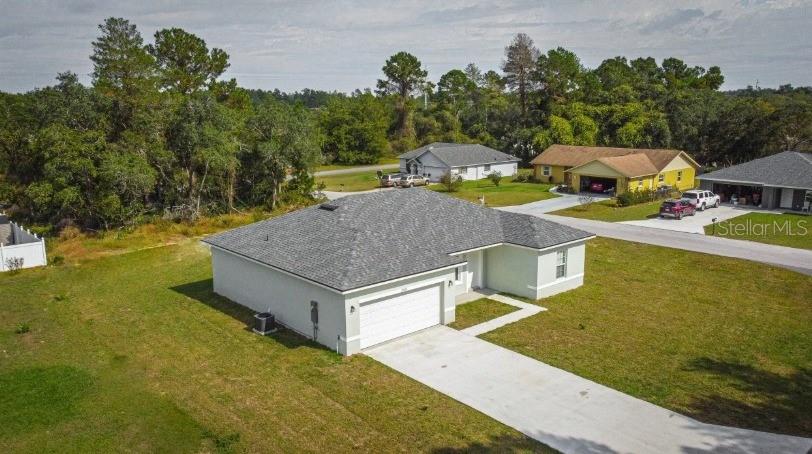 A single-story house with a white exterior, a two-car garage, and a grassy yard — 6346 N DARLINGTON DRIVE, DUNNELLON, FL