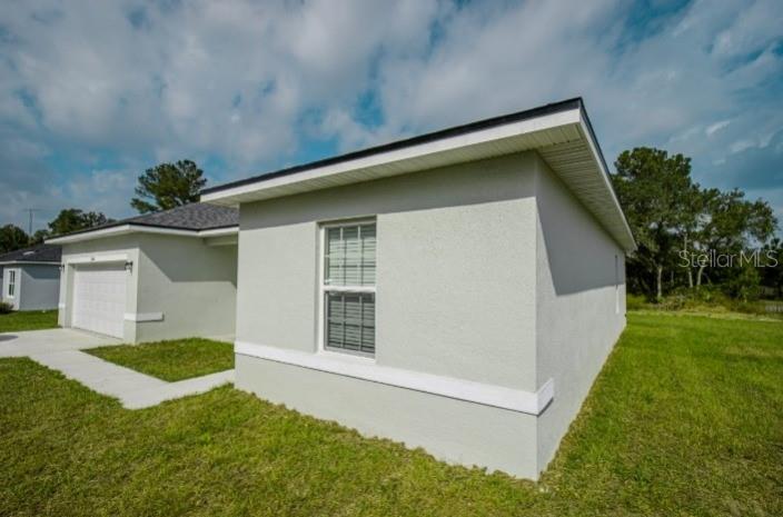 A single-story house with a white exterior, a two-car garage, and a concrete driveway — 6346 N DARLINGTON DRIVE, DUNNELLON, FL