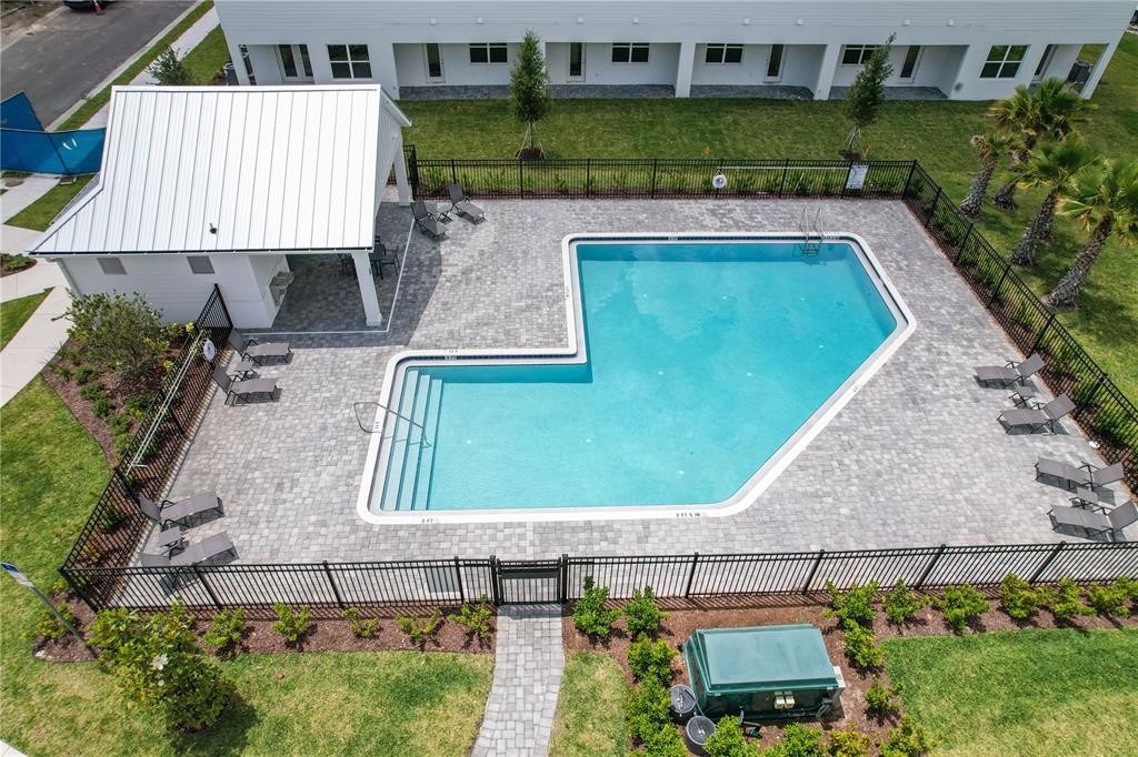 An aerial view shows a swimming pool with a covered patio area and surrounding fencing — 1519 HERITAGE PLACE, OVIEDO, FL