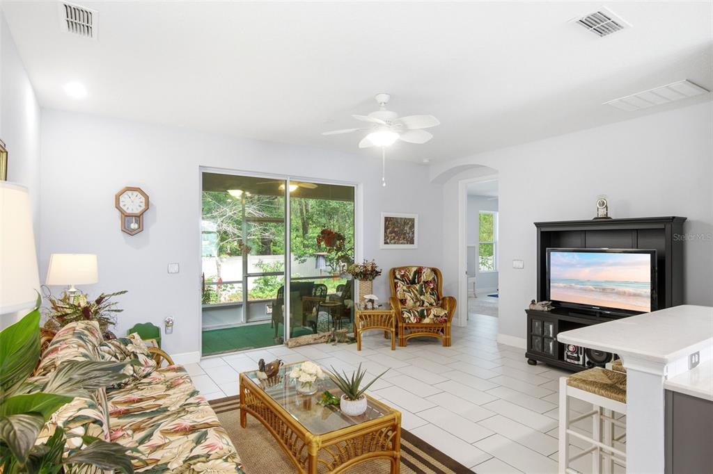 A living room with tile floors, a ceiling fan, and a sliding door to a patio — 500 BIRD SONG COURT, DELAND, FL