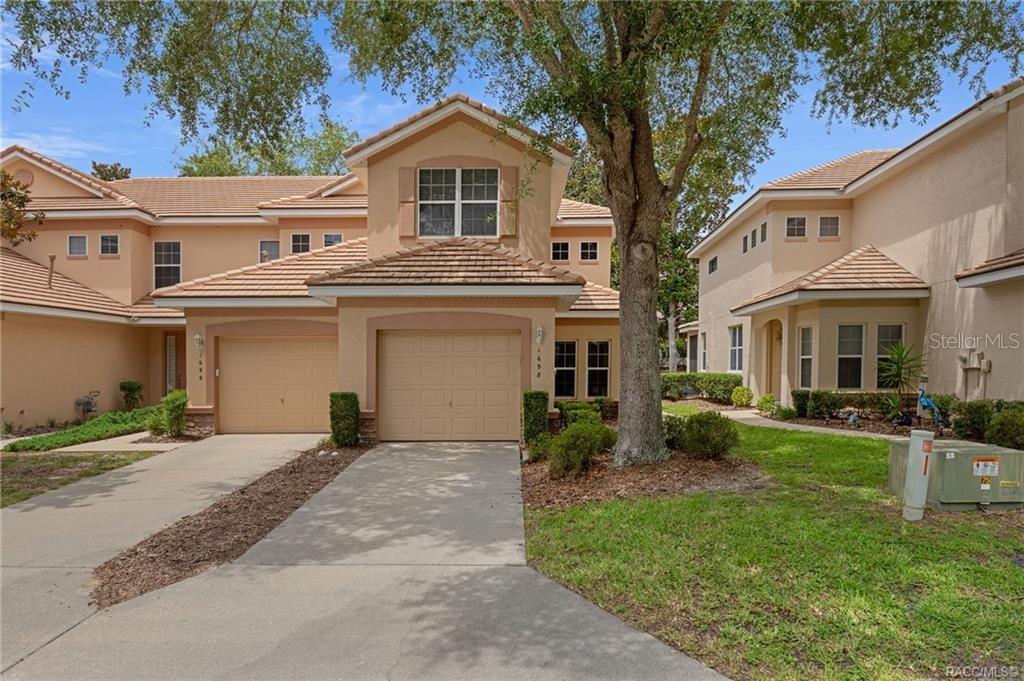 A two-story tan stucco townhouse with a tile roof and two attached garages — 1698 W SPRING MEADOW LOOP, LECANTO, FL