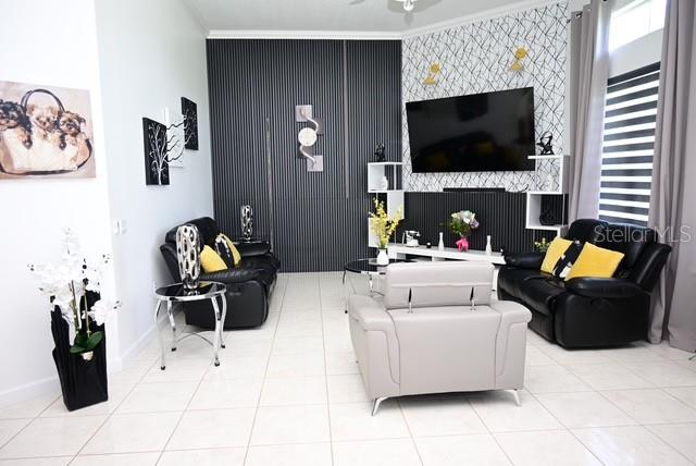 A living room features black leather furniture, a light gray armchair, and a wall-mounted television — 2270 TOURNAMENT COURT, KISSIMMEE, FL