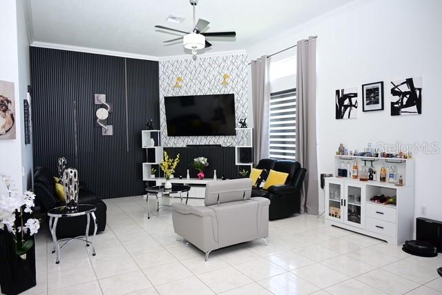 A living room features a black slatted accent wall, a television, and a white cabinet — 2270 TOURNAMENT COURT, KISSIMMEE, FL